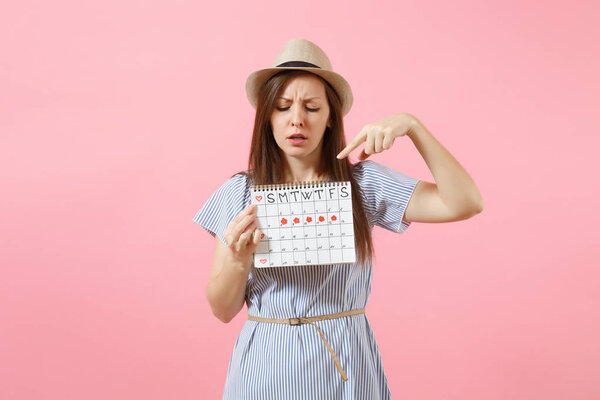 Портрет молодой женщины в синем платье, календарь периодов хранения шляпы для проверки дней менструации изолированы на ярко-трендовом розовом фоне. Медицинская, медицинская, гинекологическая концепция. Копирование пространства
