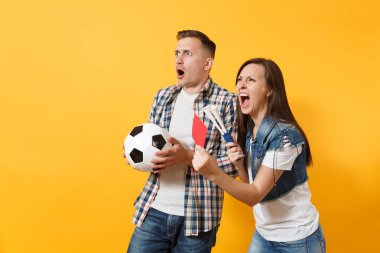 Genç kızgın expessive çift, destek ekibi ile futbol topu, kadın adam ayaktopu fans neşelen boru kırmızı kart için emekli üzerinde sarı arka plan izole alanından. Spor aile eğlence yaşam tarzı kavramı