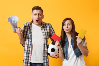Expessive çılgın çift, kadın erkek futbol hayranları çığlık, kaybı, üzgün favori takım gol futbol topu, kırmızı kart, sarı zemin üzerine izole megafon ile. Spor aile yaşam tarzı kavramı
