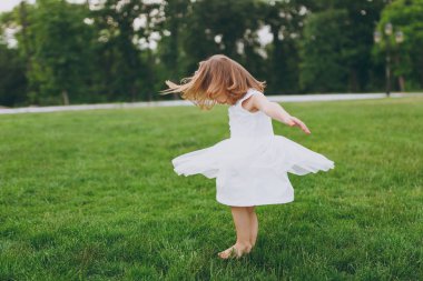 Sevimli küçük şirin çocuk bebek kız ışık çember elbise ve Park yeşil çim çim üzerinde iyi eğlenceler. Anne, küçük çocuk kızı. Anneler günü, aşk aile, ebeveynlik, çocukluk kavramı