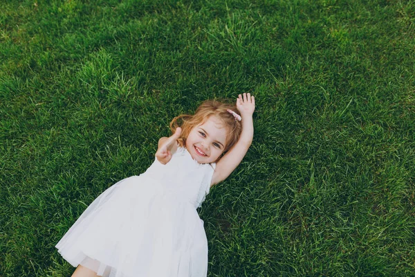 Sorrindo Pequena Menina Bebê Bonito Luz Vestido Mentira Gramado Grama — Fotografia de Stock