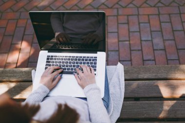 Kırpılan başarılı eller klavye üzerinde kapatın. Modern dizüstü pc bilgisayar açık havada sokakta boş boş ekran ile çalışan bankta oturan kadın. Mobile Office serbest iş kavramı