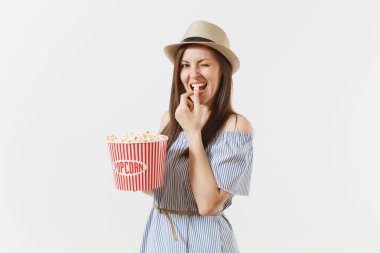 Mavi elbiseli, yeme patlamış mısır kova tutarak film film izlerken şapka genç kadın beyaz arka plan üzerinde izole. İnsanlar, sinema, yaşam kavramı samimi duygular. Reklam alanı. Kopya alanı