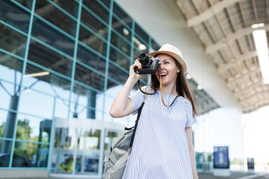 Genç seyahat etmek turist kadın Uluslararası Havaalanı'nda retro vintage fotoğraf makinesinde fotoğraf çekmek sırt çantası ile. Hafta sonu kaçış üzerinde seyahat için yurt kadın yolcu. Hava uçuş kavramı