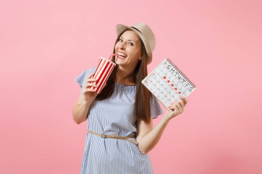 Soda, pembe arka plan izole adet gün kontrol etmek için kadın dönemleri takvim fincan tutan mavi elbiseli mutlu kadın portresi. Tıbbi sağlık jinekolojik kavramı. Kopya alanı