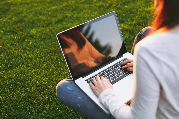 Eller klavye üstüne kapatın. Yeşil çim Güneş'ın bahçesinde açık havada park alanı kopyalamak için dizüstü pc bilgisayar boş siyah Boþ ekran ile üzerinde çalışan kadın. Mobil ofis. Serbest iş kavramı
