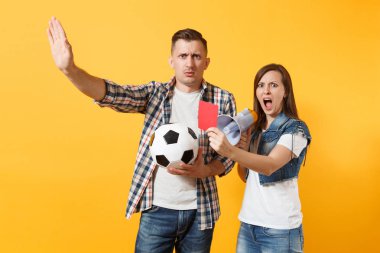 Kızgın eğlenceli expessive çılgın çift, çığlık, kadın erkek futbol taraftarları destek ekibi ile futbol topu, megafon, izole sarı zemin üzerine kırmızı kart neşelendirmek. Spor aile eğlence yaşam tarzı kavramı