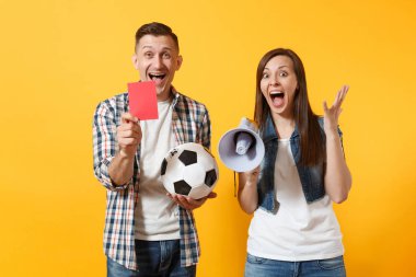 Destek ekibi futbol topu, megafon, izole sarı zemin üzerine kırmızı kart ile eğlenceli expessive çılgın çift, kadın erkek futbol hayranları çığlık, neşelen. Spor aile eğlence yaşam tarzı kavramı