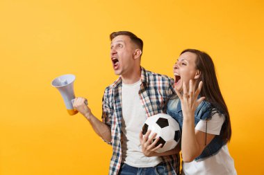 Kızgın expessive çılgın çift, kadın erkek futbol hayranları çığlık, üzgün kaybı, futbol topu, sarı zemin üzerine izole megafon ile favori takım amacı. Spor aile eğlence yaşam tarzı kavramı