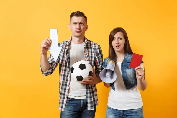 Angry couple woman man football fans screaming, cheer up support team with soccer ball, down arrow, megaphone, red card isolated on yellow background. Sport family leisure lifestyle concept.