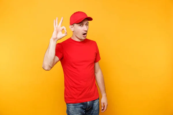 Delivery Man Het Rood Uniform Geïsoleerd Geel Oranje Achtergrond Professionele — Stockfoto