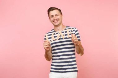 Word'de çizgili tişört ahşap duygusal genç adam portresi izole üzerinde gidişli pastel pembe arka plan seviyorum. İnsanlar samimi duygular yaşam tarzı tatil kavramı. Alan kopya alanı için reklam