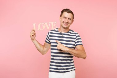 Word'de çizgili tişört ahşap duygusal genç adam portresi izole üzerinde gidişli pastel pembe arka plan seviyorum. İnsanlar samimi duygular yaşam tarzı tatil kavramı. Alan kopya alanı için reklam