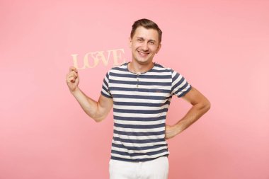 Word'de çizgili tişört ahşap duygusal genç adam portresi izole üzerinde gidişli pastel pembe arka plan seviyorum. İnsanlar samimi duygular yaşam tarzı tatil kavramı. Alan kopya alanı için reklam