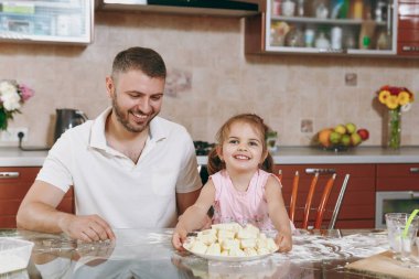 Küçük çocuk kız adam ışık mutfak masasında tembel köfte yemek için yardım. Mutlu aile baba, çocuk kızı evde hafta sonu sabah yemek yemek. Babalar günü tatil. Ebeveynlik çocukluk kavramı