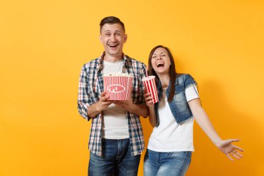 Sarı arka plan üzerinde rahat kıyafetler film film izlerken patlamış mısır plastik bardak kola veya kola kova tutarak tarihte mutlu gülen kaç kadın genç erkeklerde izole. Sinema kavramı duygular