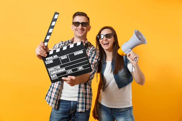 年轻幸福微笑的情侣在3D 眼镜的男子观看电影的日期举行的经典黑色电影制作 Clapperboard 和扩音器孤立的黄色背景 情感在戏院概念 — 图库照片