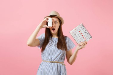 Üzgün kadın adet gün arka plan üzerinde izole kontrol hapları, kadın dönemleri takvim, beyaz şişe tutan mavi elbiseli portresi. Tıbbi sağlık, jinekolojik kavramı. Kopya alanı