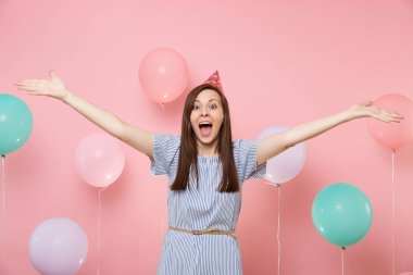 Hayret mutlu kadın Doğum günü şapka mavi elbise screming elleri pastel pembe renkli hava baloons zemin üzerine yayılan portresi. Doğum günü tatil partisi, insanlar samimi duygular kavramı