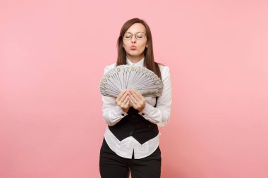 Paket çok dolar tutan gözlüklü genç iş kadını, nakit para öpüşme dudak şişirme, pembe arka plan izole. Bayan patron. Başarı kariyer servet kavramı. Kopya alanı reklam için