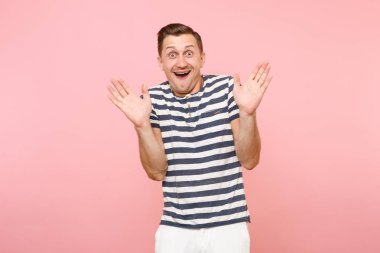 Neşeli portre genç hipster adam dresssed rahat çizgili tişört gidişli pembe Yayilim eller izole içinde şaşırttı. İnsanlar samimi duygular, gençlik yaşam tarzı kavramı.