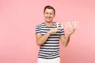 Word'de çizgili tişört ahşap duygusal genç adam portresi izole üzerinde gidişli pastel pembe arka plan seviyorum. İnsanlar samimi duygular yaşam tarzı tatil kavramı. Alan kopya alanı için reklam