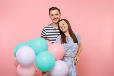 Aşık genç mutlu gülümseyen çift portresi. Pastel pembe renkli hava Balonlu Parti kadın ve Doğum günü tatil kutluyor Mavi giysili adam. İnsanlar samimi duygular kavramı