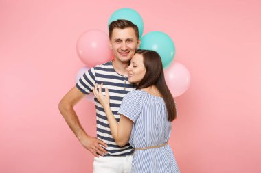 Aşık genç mutlu gülümseyen çift portresi. Kadın bir adam göğüs kutluyor Doğum günü tatile yağsız parti renkli hava balonları pastel pembe zemin üzerine. İnsanlar samimi duygular kavramı