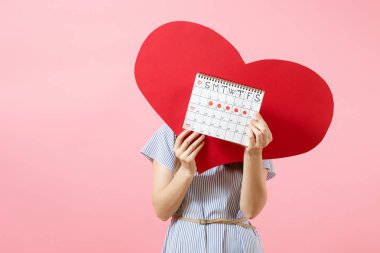 Mutlu kadın adet gün kontrol mavi elbise yaz şapkalı boş boş kırmızı kalp, kadın dönemleri takvim, holding arka plan üzerinde izole. Tıbbi sağlık jinekolojik kavramı. Kopya alanı