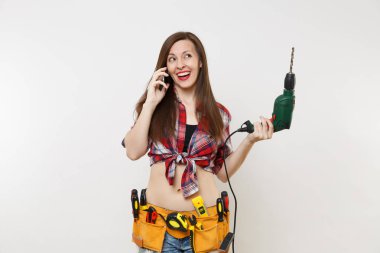 Genç enerji ev erkeği kadın ekose gömlekli, kit araçları kemer cep telefonda konuşurken araçların tam beyaz arka plan üzerinde izole elektrikli matkap tutun. Kadın erkek iş. Yenileme kavramı