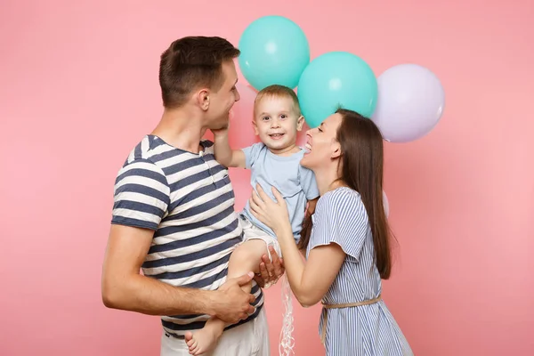 幸せな親の誕生日を祝ってのハグ子供子供息子赤ちゃん男の子のキスを腕の中で保つ若者の肖像ホリデー パーティーにカラフルな気球とパステル ピンクの背景 心から感情の概念 — ストック写真