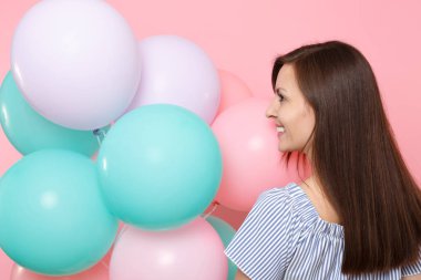 Mavi elbiseli güzel ihale genç mutlu kadın geri dikiz renkli hava balonları bir kenara izole üzerinde parlak pembe arka plan seyir tutun. Doğum günü tatil partisi, insanlar samimi duygular kavramı