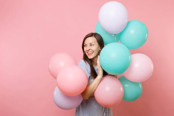 Renkli hava balonları bir kenara parlak pembe izole kopya alanı bakmak tutan mavi elbiseli hoş gülümseyen genç kadın portresi. Doğum günü tatil partisi, insanlar samimi duygular kavramı