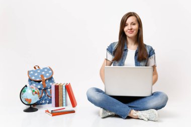 Genç casual oldukça gülümseyen kadın öğrenci Holding dünya oturan dizüstü pc bilgisayar kullanan sırt çantası, beyaz arka plan üzerinde izole okul kitapları. Lise Üniversite kavramı kolej eğitim