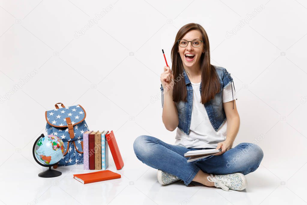 Young amazed woman student enlightened with new thought pointing pencil up holding notebook near globe backpack, school books isolated on white background. Education in high school university college