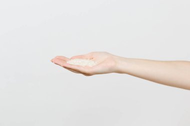 Kadın bekle el avuç Yasemin Tay çiğ pirinç beyaz arka plan üzerinde izole kapatmak. Doğru beslenme, vegan gıda Vejetaryen beslenme, sağlıklı yaşam konsepti diyet. Kopyalama alanı reklam