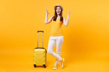 Seyahat etmek turist kadın yaz rahat kıyafetler, sarı turuncu arka plan üzerinde izole çanta şapka. Hafta sonu kaçış üzerinde seyahat için yurt kadın yolcu. Hava uçuş yolculuk kavramı