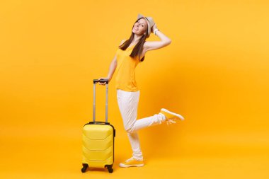 Seyahat etmek turist kadın yaz rahat kıyafetler, sarı turuncu arka plan üzerinde izole çanta şapka. Hafta sonu kaçış üzerinde seyahat için yurt kadın yolcu. Hava uçuş yolculuk kavramı