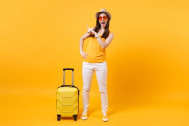 Seyahat etmek turist kadın yaz rahat kıyafetler, sarı turuncu arka plan üzerinde izole çanta şapka. Hafta sonu kaçış üzerinde seyahat için yurt kadın yolcu. Hava uçuş yolculuk kavramı