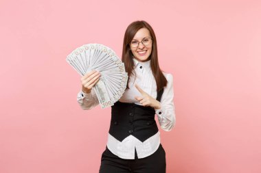 İşaret parmağı dolar, sürü paket üzerinde nakit para, pembe arka plan izole gözlüklü genç gülümseyen iş kadını. Bayan patron. Başarı kariyer servet. Kopya alanı reklam için