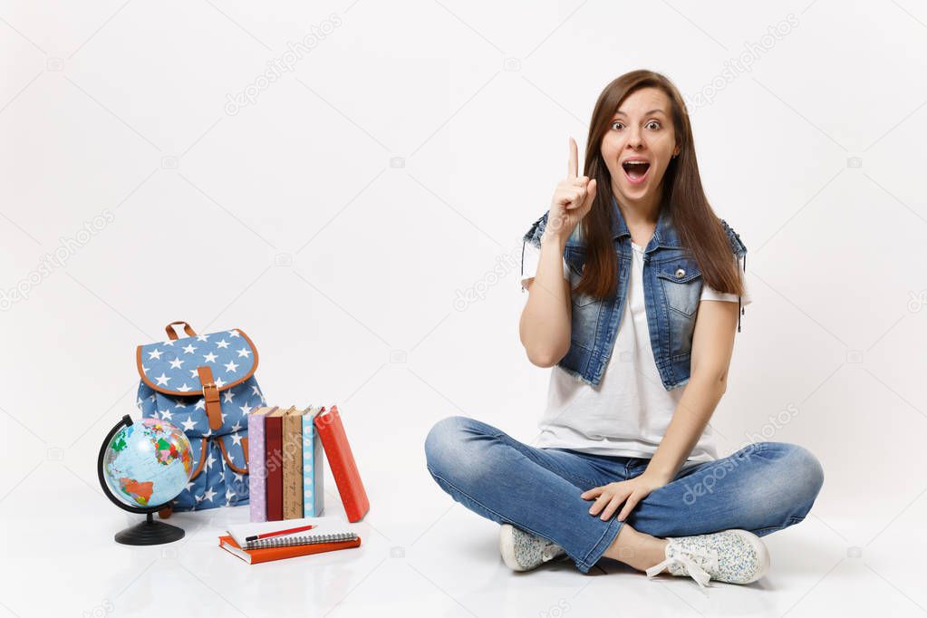 Young excited woman student enlightened with new thought, idea pointing index finger up sit near globe, backpack school books isolated on white background. Education in high school university college