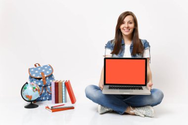 Genç kadın öğrenci dizüstü pc bilgisayar boş siyah Boþ ekran oturan küre sırt çantası yakınındaki beyaz arka plan üzerinde izole okul kitapları tutan güzel. Eğitimde yüksek okul üniversiteler