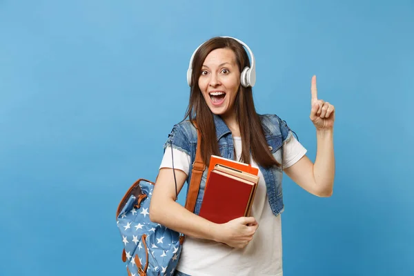 Молодая Удивленная Студентка Рюкзаками Наушниках Слушающая Музыку Держит Школьную Книгу — стоковое фото