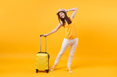 Seyahat etmek turist kadın yaz rahat kıyafetler, sarı turuncu arka plan üzerinde izole çanta şapka. Hafta sonu kaçış üzerinde seyahat için yurt kadın yolcu. Hava uçuş yolculuk kavramı