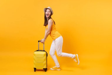 Seyahat etmek turist kadın yaz rahat kıyafetler, sarı turuncu arka plan üzerinde izole çanta şapka. Hafta sonu kaçış üzerinde seyahat için yurt kadın yolcu. Hava uçuş yolculuk kavramı