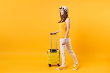 Seyahat etmek turist kadın yaz rahat kıyafetler, sarı turuncu arka plan üzerinde izole çanta şapka. Hafta sonu kaçış üzerinde seyahat için yurt kadın yolcu. Hava uçuş yolculuk kavramı