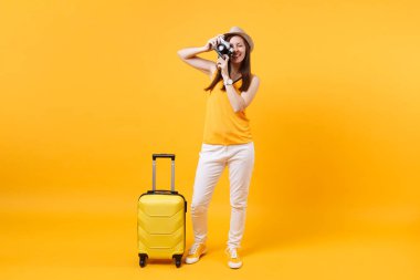 Yaz rahat kıyafetler çanta, retro vintage fotoğraf makinesi üzerinde sarı turuncu arka plan izole kadın turist. Hafta sonu kaçış üzerinde seyahat için yurt dışında seyahat yolcu. Hava uçuş kavramı