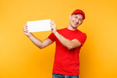 Teslimatçı sarı turuncu arka plan üzerinde izole kırmızı üniforma. Profesyonel erkek çalışan kurye şapkalı t-shirt beyaz boş boş kağıt tutun. Hizmet anlayışı. Metin veya resim için yer yer kopyalayın
