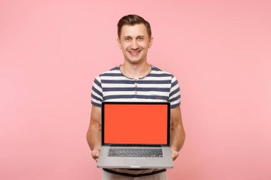 Elinde boş siyah Boþ ekran görüntü kopyalama alanı pastel pembe arka plan üzerinde izole olan dizüstü bilgisayar tutan genç adam portresi. İnsanlar samimi duygular yaşam tarzı kavramı. Reklam alanı