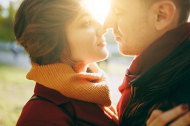 Görüntü genç romantik çift kadın adamı rahat kıyafetler birbirine yürüyüş sonbahar Şehir Park açık havada güneşli bir günde bakarak sarılma kucaklayan kırpılmış. Aşk ilişki aile yaşam tarzı kavramı